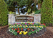 Thumbnail 2 of 23 - Stone Welcome Sign to Pinewood Square Apartment Homes with Flower Bed Below at Pinewood Square Apartment Homes, WA 98087