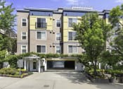 Thumbnail 2 of 27 - an apartment building with a driveway and trees in front of it at Sir Gallahad Apartment Homes, Bellevue, WA