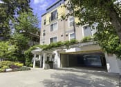Thumbnail 3 of 27 - a large apartment building with a parking lot in front of it at Sir Gallahad Apartment Homes,  Bellevue, 98004