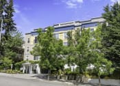 Thumbnail 4 of 27 - a large apartment building with trees in front of it at Sir Gallahad Apartment Homes, WA 98004