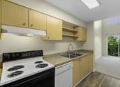 Thumbnail 16 of 27 - a kitchen with wooden cabinets and a white stove top oven at Sir Gallahad Apartment Homes, Bellevue, 98004