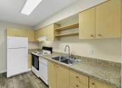 Thumbnail 20 of 27 - Modern Style Kitchen with Wooden Cabinetry, Plank Flooring, and White Refrigerator at Sir Gallahad Apartment Homes, Bellevue, Washington 98004
