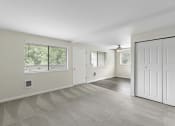 Thumbnail 22 of 30 - Living room with a closet and a window at Swiss Gables Apartment Homes, Kent, WA