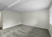 Thumbnail 15 of 30 - a bedroom with tan walls and a gray carpet at Swiss Gables Apartment Homes, WA 98032