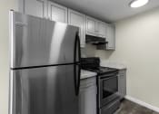 Thumbnail 24 of 30 - a kitchen with stainless steel appliances and white cabinets at Swiss Gables Apartment Homes, Kent, Washington 98032