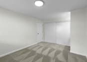 Thumbnail 23 of 30 - a bedroom with white walls, gray carpet, and overhead lighting at Swiss Gables Apartment Homes, Kent, 98032