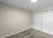 Thumbnail 10 of 30 - a bedroom with two closet doors and a carpeted floor at Swiss Gables Apartment Homes, Kent, WA