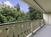 Thumbnail 4 of 30 - a balcony with trees in the background at Swiss Gables Apartment Homes, Kent, WA