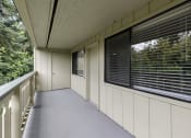 Thumbnail 12 of 30 - a large balcony with a view of the trees at Swiss Gables Apartment Homes, Kent, Washington 98032