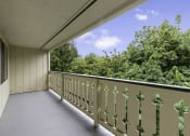 Thumbnail 9 of 30 - a large balcony with a view of the treeline at Swiss Gables Apartment Homes, WA 98032