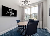 Thumbnail 29 of 75 - a conference room with a table and chairs and a tv on the wall  at Griffin Weston, Cary, North Carolina