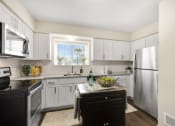 Thumbnail 5 of 31 - a kitchen with white cabinets and a black island with a bottle of wine on it  at Northridge, Rochester Hills, Michigan