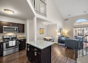 Thumbnail 13 of 23 - A modern kitchen with dark wood floors and a large island at MainCentre, Northville