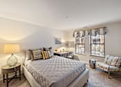 Thumbnail 6 of 23 - A bedroom with a large bed and a chair at MainCentre, Northville