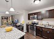 Thumbnail 2 of 23 - A modern kitchen with granite countertops and stainless steel appliances at MainCentre, Northville
