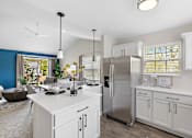 Thumbnail 2 of 24 - A modern kitchen with a stainless steel refrigerator and white cabinets at Briarcliff Village, Michigan, 48390
