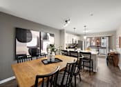 Thumbnail 4 of 26 - A modern dining room with a wooden table and chairs.