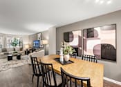 Thumbnail 5 of 26 - A modern dining room with a wooden table and chairs.