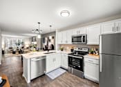 Thumbnail 7 of 26 - A modern kitchen with stainless steel appliances and white cabinets.