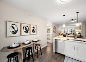 Thumbnail 8 of 26 - A kitchen with a white counter and black stools.
