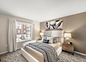 Thumbnail 9 of 26 - A bedroom with a large bed and a window with white curtains.