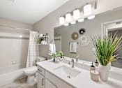 Thumbnail 10 of 26 - A bathroom with a white tub, sink, and toilet.