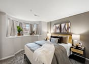 Thumbnail 11 of 26 - A bedroom with a large bed and a window with curtains.