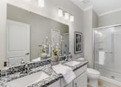 Thumbnail 10 of 20 - A bathroom with a marble countertop and a toilet at Park West, Canton, 48187