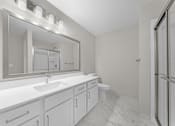 Thumbnail 15 of 22 - A bathroom with a sink, mirror, toilet, and a walk-in shower at Amberly Apartments, West Bloomfield, 48322