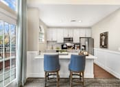 Thumbnail 15 of 18 - A kitchen with a white countertop and blue chairs.
