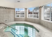 Thumbnail 13 of 18 - A small indoor pool with a metal railing.