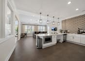 Thumbnail 23 of 34 - a large kitchen with white cabinets and a white counter top at Cidermill Village Apartments in Rochester Hills, MI 