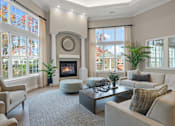 Thumbnail 19 of 34 - a living room with couches and chairs and a fireplace at Cidermill Village Apartments in Rochester Hills, MI 