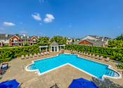 Thumbnail 34 of 34 - an aerial view of a swimming pool with chairs and umbrellas at Cidermill Village Apartments in Rochester Hills, MI 