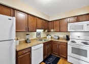 Thumbnail 26 of 31 - a kitchen with white appliances and brown cabinets  at Northridge, Rochester Hills, MI