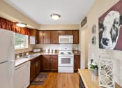 Thumbnail 11 of 31 - a kitchen with white appliances and wooden cabinets  at Northridge, Rochester Hills, MI, 48307