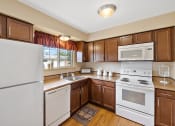 Thumbnail 13 of 31 - a kitchen with white appliances and brown cabinets at Northridge, Michigan, 48307