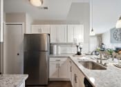 Thumbnail 20 of 31 - a kitchen with white cabinets and granite countertops  at Northridge, Rochester Hills, MI, 48307