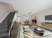 Thumbnail 2 of 17 - A living room with a grey couch and a coffee table.