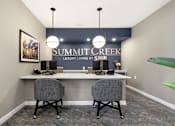 Thumbnail 18 of 23 - Two grey chairs are placed in front of a desk with a Summit Creek sign on the wall.
