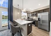 Thumbnail 20 of 23 - A modern kitchen with a large island and stainless steel appliances.