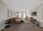 Thumbnail 3 of 16 - A living room with a brown couch and a television on the wall.