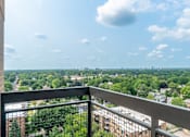 Thumbnail 24 of 25 - A balcony overlooks a lush green landscape.