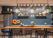 Thumbnail 3 of 25 - A modern kitchen with a wooden table and chairs.