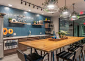 Thumbnail 9 of 25 - A modern kitchen with a wooden table and chairs.