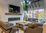Thumbnail 2 of 25 - A living room with a fireplace and a television mounted above it.
