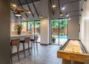 Thumbnail 7 of 25 - A room with a pool table and bar stools.