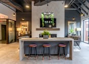 Thumbnail 8 of 25 - A modern bar area with a grey counter and red stools.