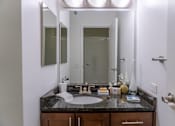 Thumbnail 22 of 25 - A bathroom with a sink, mirror, and a door.