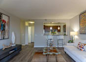 Thumbnail 16 of 25 - A living room with a white couch and a coffee table.